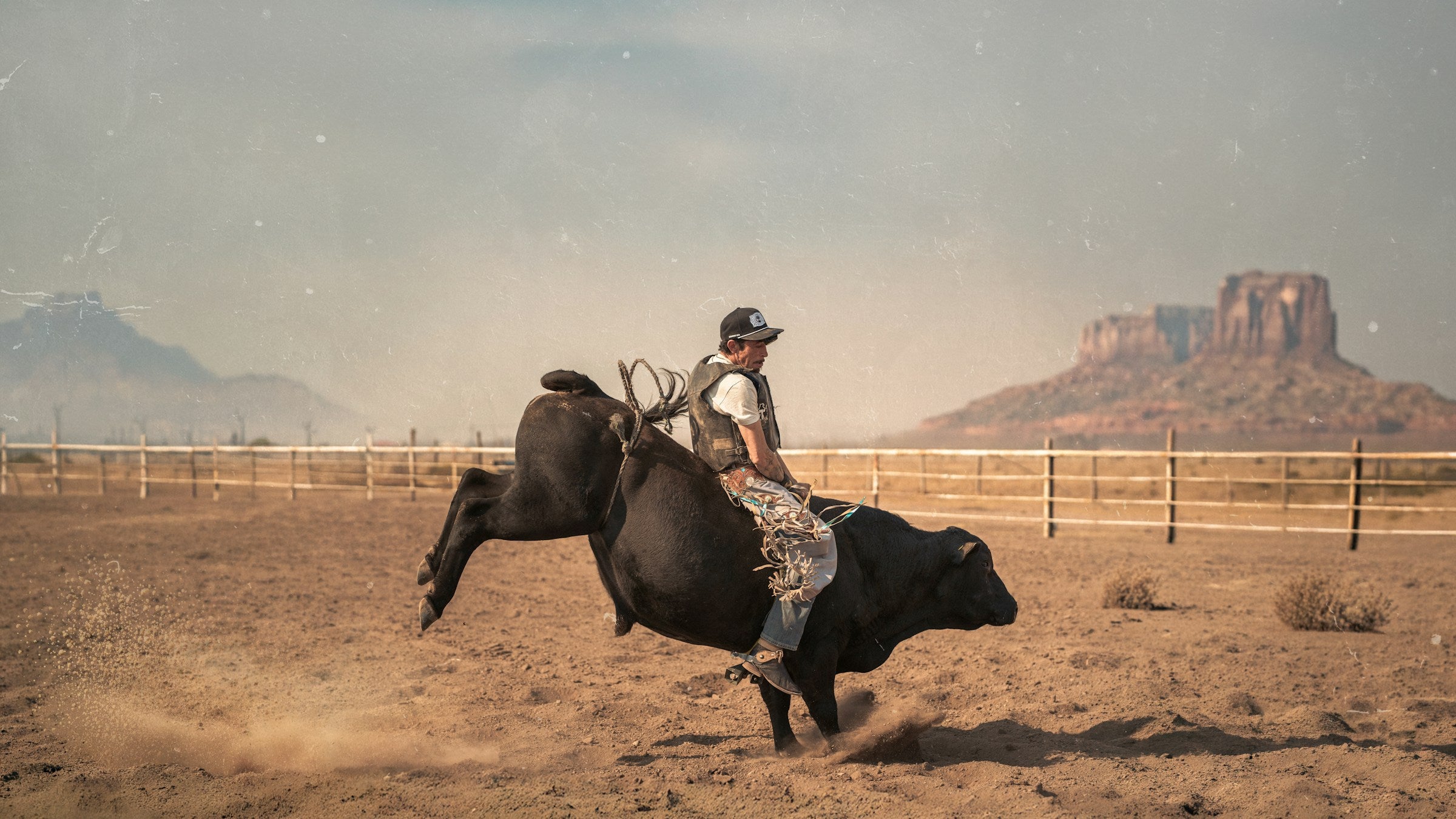 Bull rider in a dusty arena